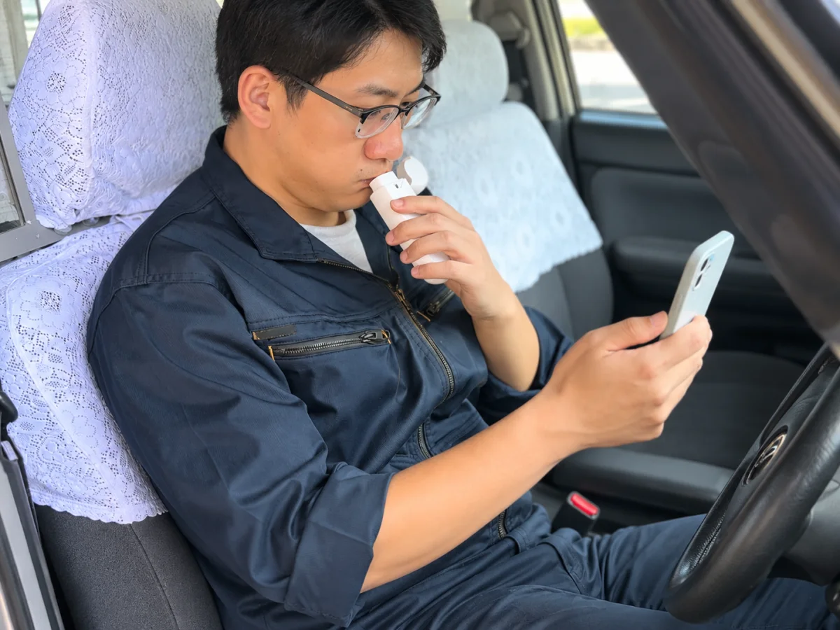 車内でピッとパッ!を使い、スマートフォンと連携して測定する運転者